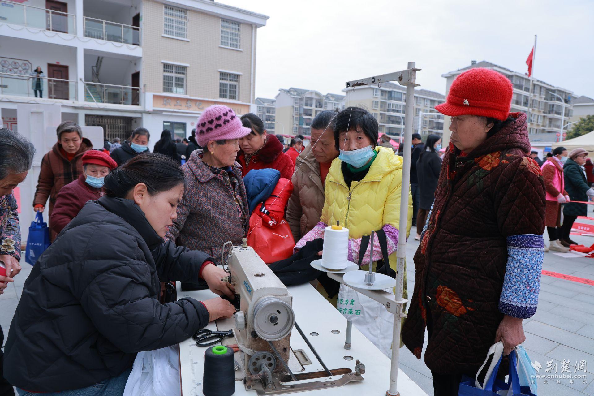 衣物縫補(bǔ)攤前，志愿者飛針走線為居民修補(bǔ)破損衣物.jpg.jpg